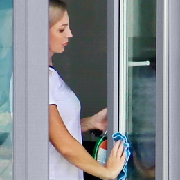 Девушка моет пластиковое окно